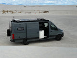 Adventure-ready grey camper van RV rental in the vast White Sands desert, ideal for off-grid trips.
