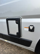 Side of an RV rental: external 30-amp electrical hookup with warning label and an access panel are visible on the silver exterior.