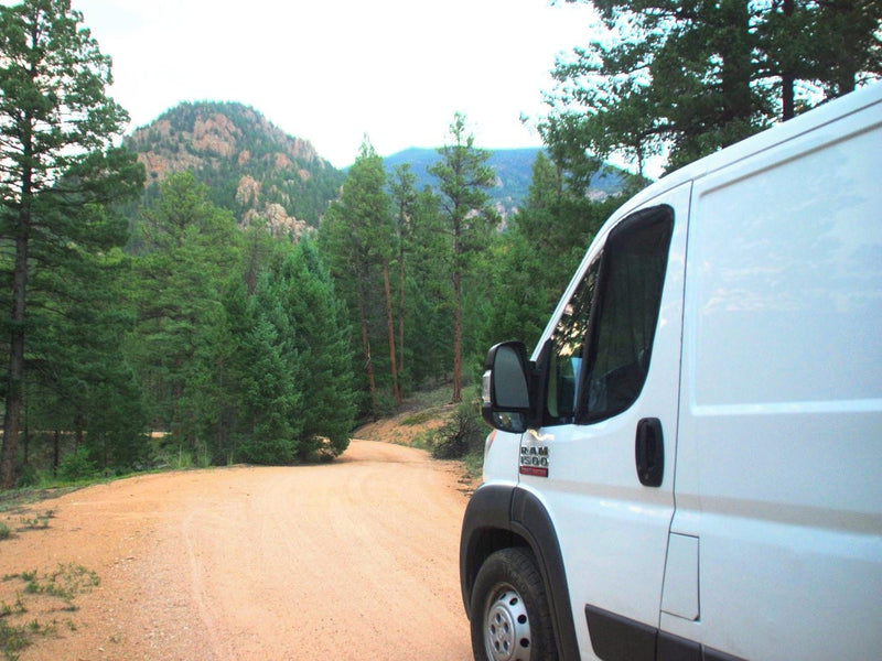  relaxing outdoors.|Cozy Ram ProMaster camper van conversion with open door — photo 8