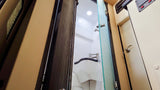 Compact RV bathroom with shower and sink, seen through an open door. Ideal for rv rental adventures.