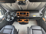 Dashboard view of a Mercedes-Benz RV rental, featuring wood trim, steering wheel, and a sunshade.