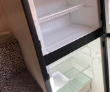 Compact, clean refrigerator interior of an RV rental, showing wire and glass shelves. Ready for your supplies.