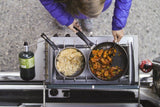Cooking a meal of rice and stir-fry on an outdoor stove, ideal for an RV rental adventure.