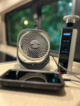 Small fan, phone charging via GFCI pop-up outlet in an RV rental. Essential for comfort and convenience on the go.