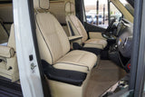 Luxurious RV rental interior showcasing quilted cream leather passenger and driver seats. Enjoy comfort on your camper van trip.