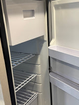 Clean, empty refrigerator inside an RV rental, showing wire shelves, door bins, and a top freezer compartment.