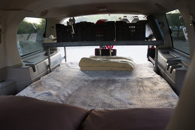  and fire extinguisher for car camping adventures.|SUV RV rental setup: Open trunk displays a bed — photo 4