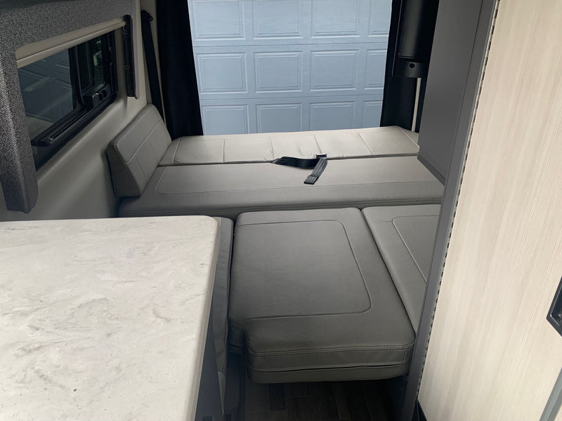  and compact kitchen offer comfort on the road.|Dark grey camper van with open side door revealing a kitchen — photo 8