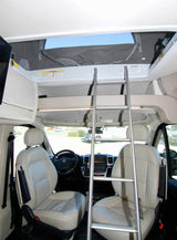 RV rental interior: front cab, dashboard, and a ladder leading to a pop-top sleeping area.