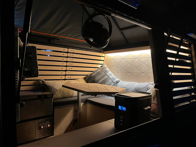 Cozy RV rental interior at night. Features comfy seating, adjustable table, and power station. Ideal for van life adventures. — photo 5