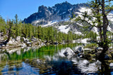 Experience breathtaking mountain landscapes! This vibrant alpine lake, surrounded by trees & snow-capped peaks, awaits your RV rental journey.