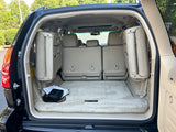 Open Lexus SUV trunk with beige interior, third-row seats folded for maximum cargo. Great for travel, like an rv rental.