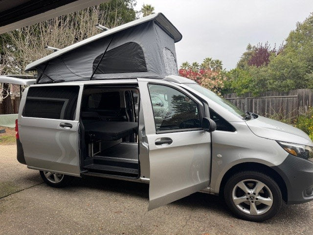 Silver pop-top camper van, ready for adventure as an RV rental. Side and front doors are open, revealing interior features. — photo 2