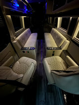 Luxurious RV rental interior featuring plush, quilted seating, ambient blue lighting, and a dark wood-look floor.