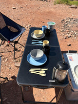 Outdoor dining setup on a portable table with tableware and French press, ideal for your RV rental campsite.