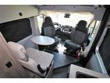 Interior of an rv rental with swiveling front seats, a dining table, and extra seating, ideal for comfortable travel.