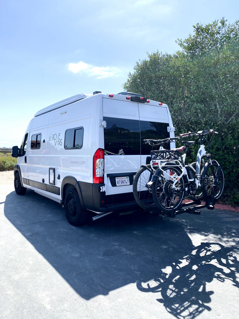 White Rove Vans camper, an RV rental, with two e-bikes on its rear rack, parked on a sunny day. — photo 17