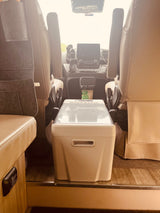 RV rental: View from rear showcasing comfortable front seats, dashboard, and a portable cooler between them.