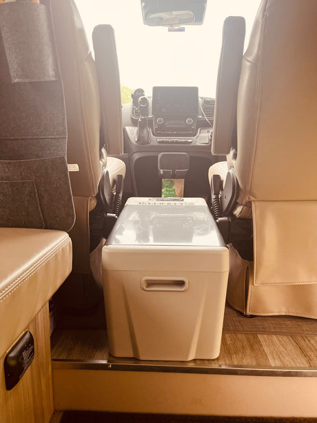 RV rental: View from rear showcasing comfortable front seats, dashboard, and a portable cooler between them.