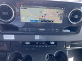 An RV rental's modern dashboard, showing the infotainment screen with navigation, climate controls, and textured carbon fiber trim.