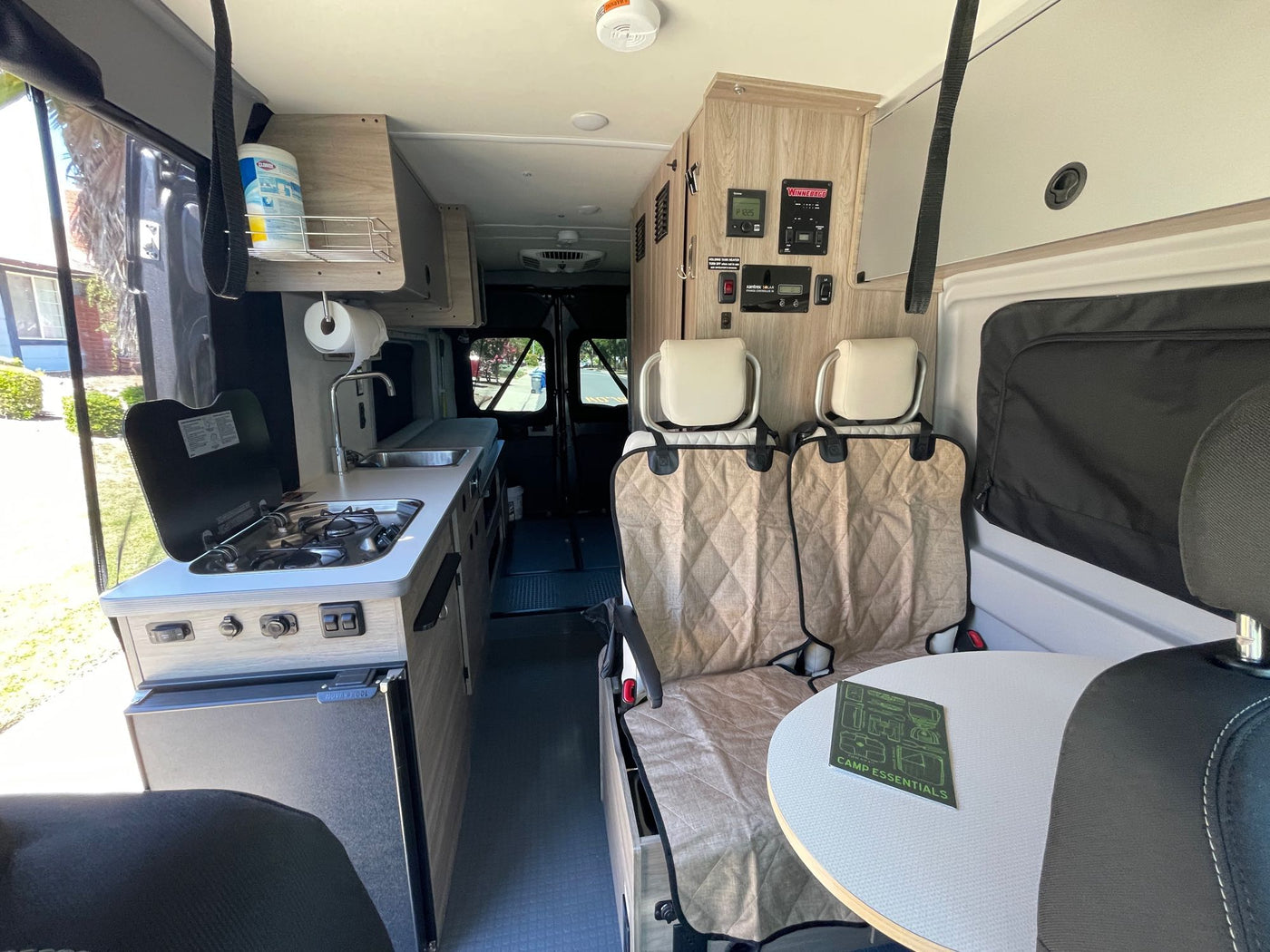 RV rental interior with a compact kitchen, control panel, and comfortable seating for your next adventure. — photo 4