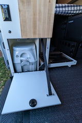 This RV rental features a compact setup with a hidden portable toilet, Dometic fridge, and pull-out storage, optimizing space.