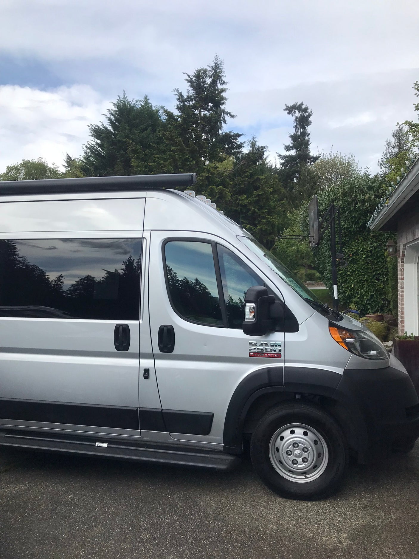 Silver Ram ProMaster camper van, a perfect RV rental parked on asphalt, ready for your road trip adventures.