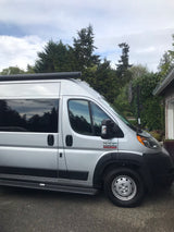 Silver Ram ProMaster camper van, a perfect RV rental parked on asphalt, ready for your road trip adventures.