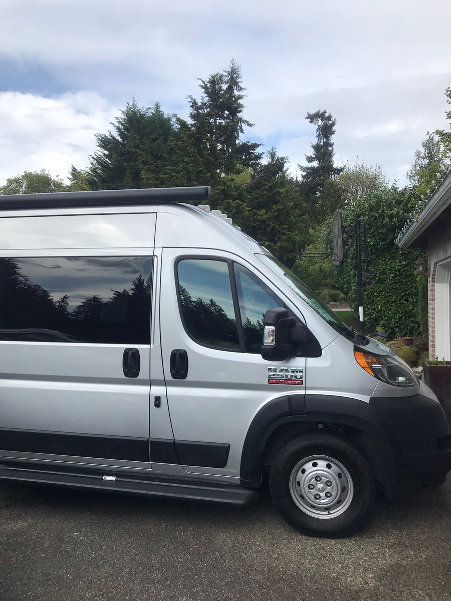 Silver Ram ProMaster camper van, a perfect RV rental parked on asphalt, ready for your road trip adventures.