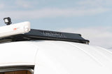 RV rental's white roof with a Fiamma F45s awning, LED light, and "Tommy Camper-Vans" custom roof rack.