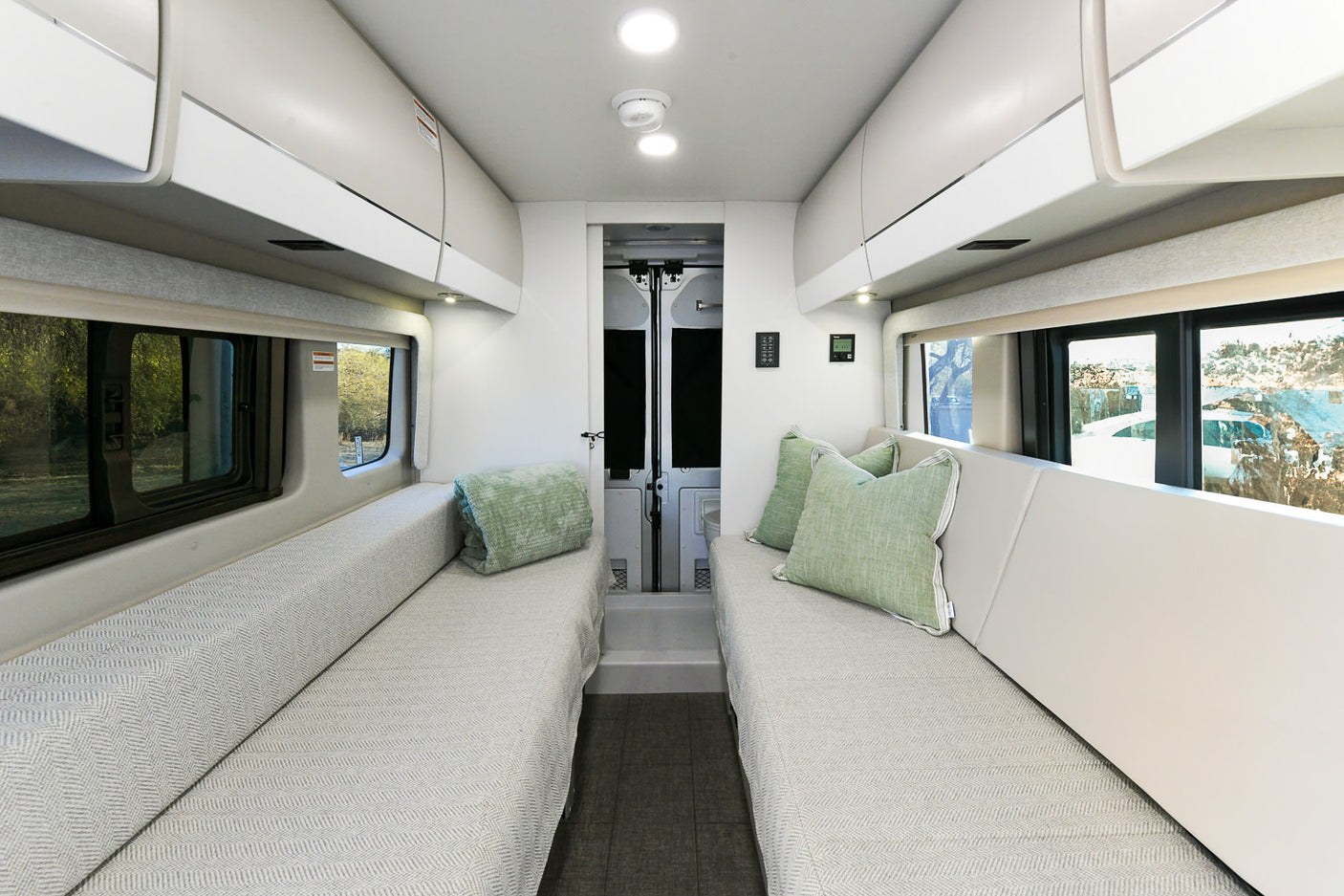 Spacious rv rental interior featuring facing sofas, overhead storage, and large windows for scenic views and comfortable travel.
