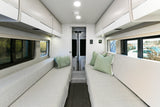 Spacious rv rental interior featuring facing sofas, overhead storage, and large windows for scenic views and comfortable travel.