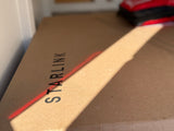 A Starlink internet kit box, marked with a red line and diagonal sunbeam, inside an RV. Ideal for rv rental Wi-Fi on the go.