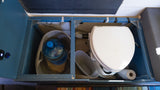 RV rental: Efficient camper storage with composting toilet & water jug in a blue custom setup.