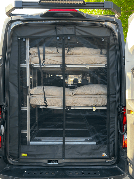Rear of an rv rental van featuring a bug screen and interior modular shelving with rolled sleeping gear, ready for adventure.