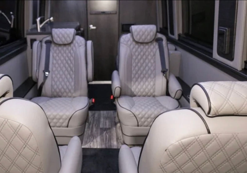 Luxury RV rental interior showcasing light cream quilted seats, modern wood-look flooring, and a compact kitchenette. — photo 7