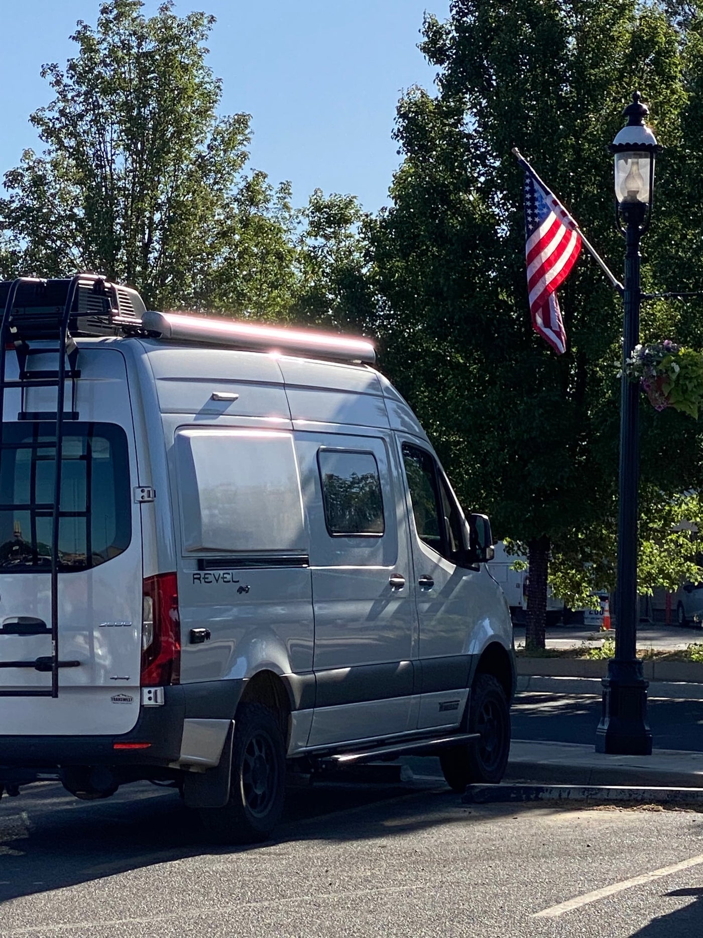  illuminated by the warm glow of a beautiful sunset. Perfect for outdoor adventures.|Light gray Revel camper van (Mercedes Sprinter type) — photo 3