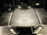 An rv rental's cockpit transforms into a temporary bed with a warning about vehicle controls & supervision.