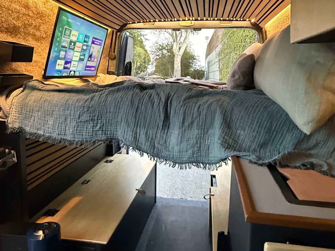  revealing interior and a surfboard outside.|RV rental interior: A modern touchscreen infotainment system and phone mount dominate the Mercedes-Benz dashboard — photo 8