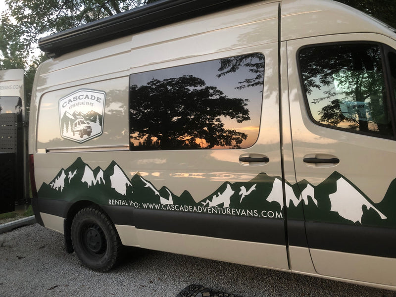 Customized adventure van for RV rental, featuring a mountain decal & sunset reflected in the window. — photo 1