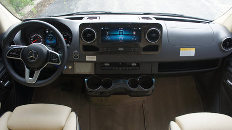 Detailed view of an RV rental's modern Mercedes-Benz Sprinter cockpit, highlighting the dashboard, infotainment system, and steering wheel.