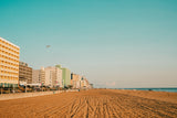 Vast sandy beach stretching along a coastline dotted with hotels and the ocean, perfect for an RV rental escape.