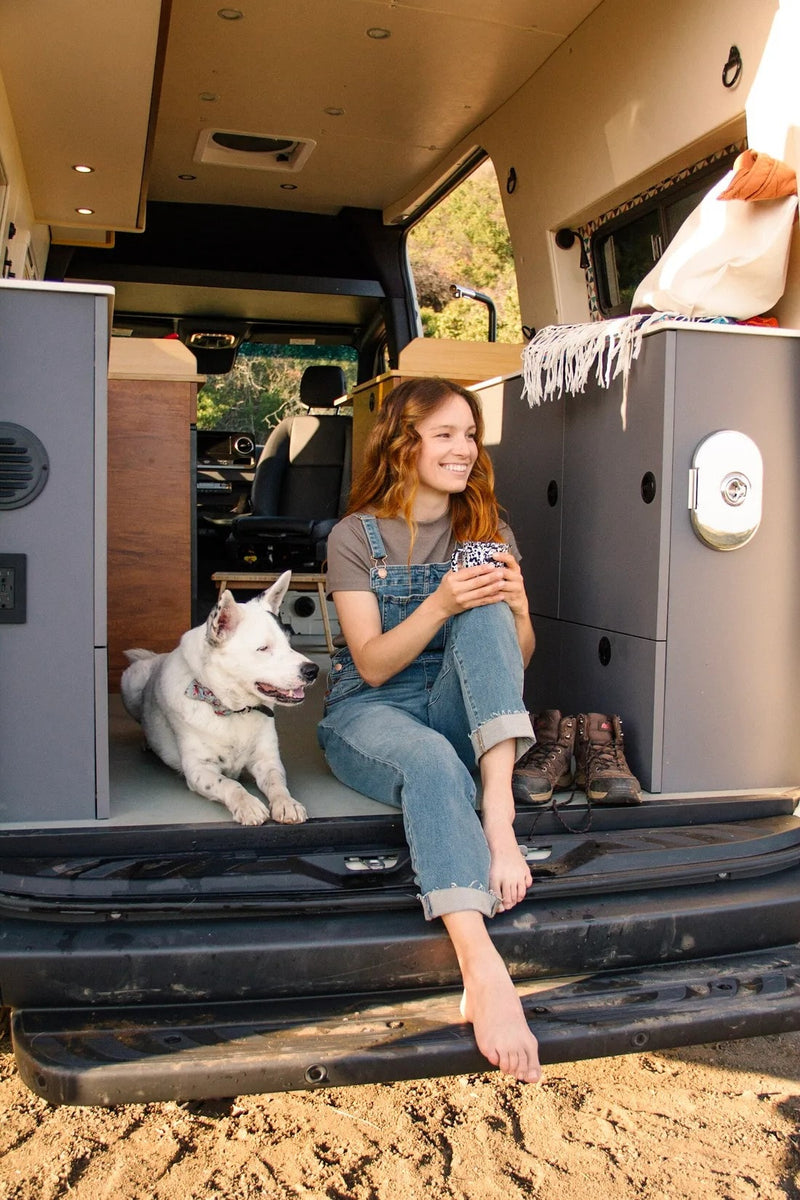  cozy seating. Ready for adventure!|Inside a cozy RV rental: A woman & her dog enjoy mountain views from the open back of their camper van kitchen.|Cozy RV rental morning: woman sips coffee — photo 11