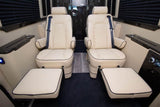 Interior of a luxury RV rental showing two cream quilted executive seats with footrests for ultimate comfort.