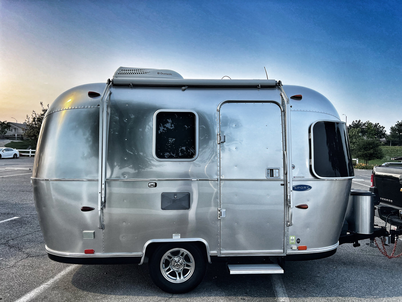 A sleek, silver Airstream travel trailer, ideal for RV rental getaways and camping adventures under a clear sky.