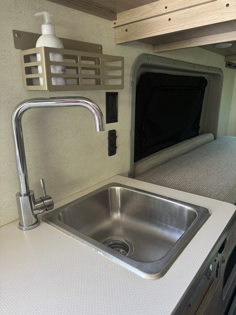 Compact RV rental kitchenette featuring a stainless steel sink, chrome faucet, and integrated storage with hand soap. — photo 6