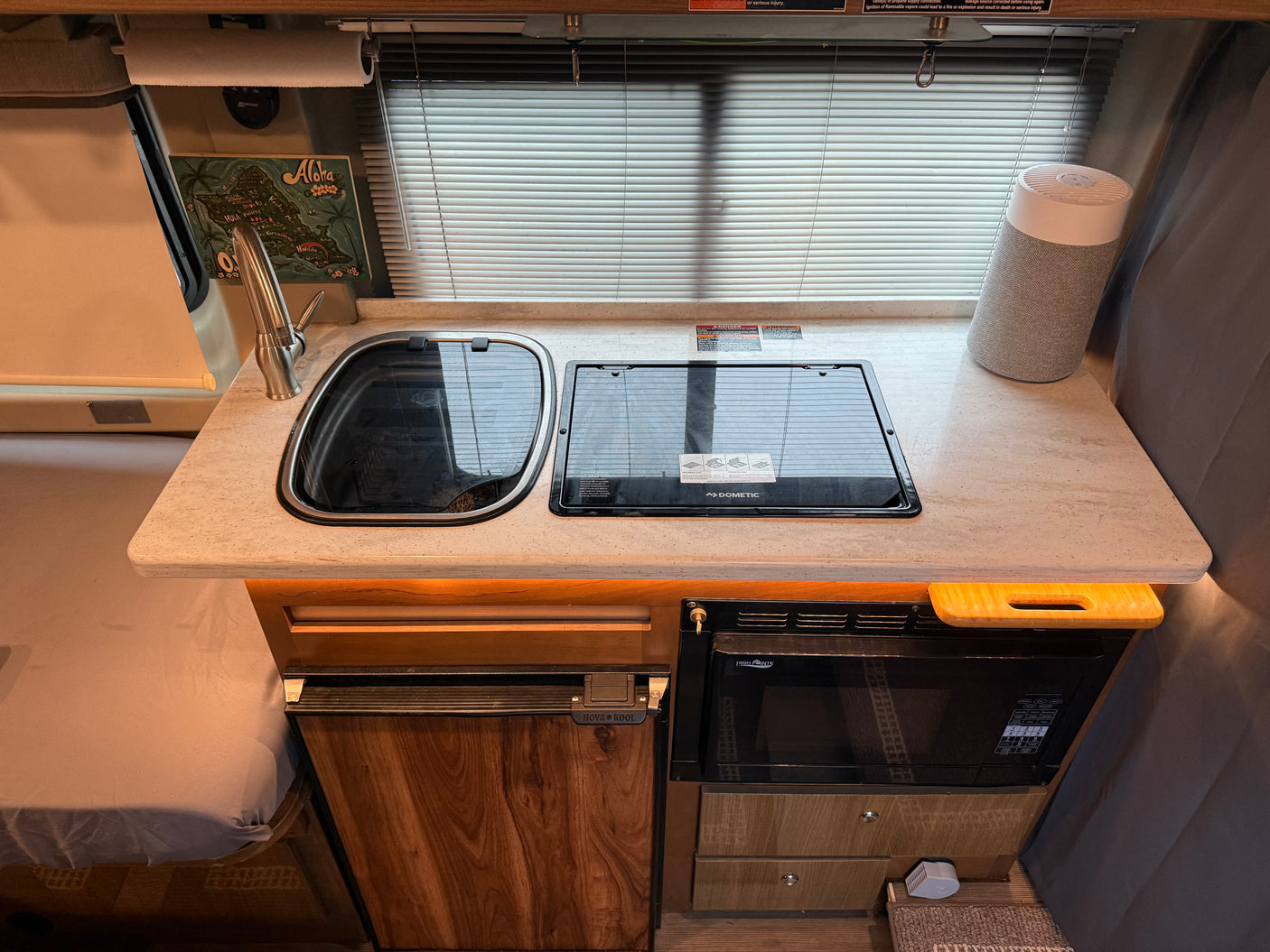 This rv rental galley features a sink, Dometic stovetop, Nova Kool fridge, High Pointe microwave, and paper towel holder.
