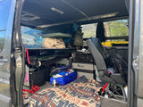 RV rental interior packed with camping gear, a fridge, and blankets, ready for a rugged outdoor adventure.