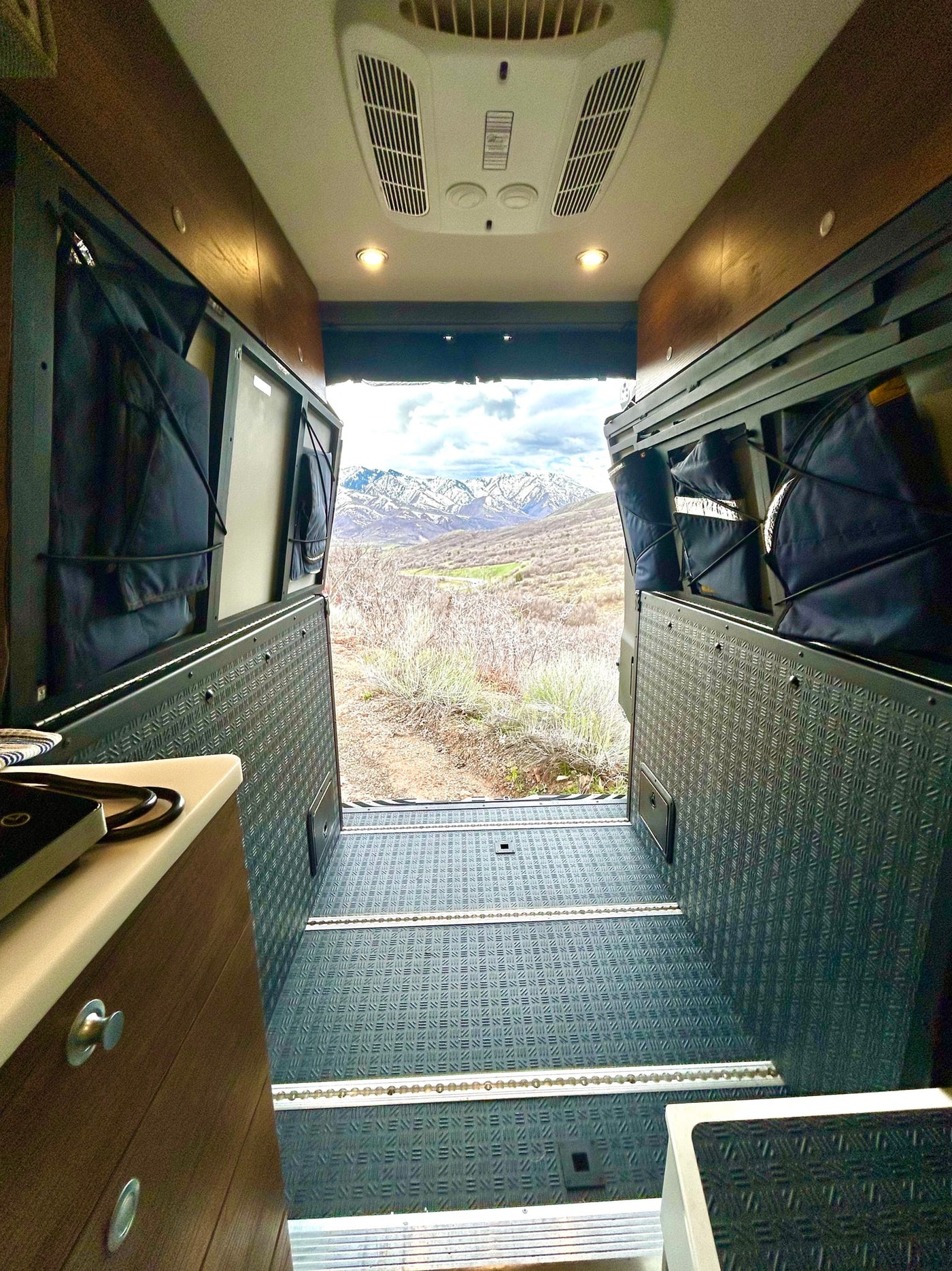 Experience the ultimate RV rental adventure! Cozy van interior with a stunning mountain view from the back. — photo 17