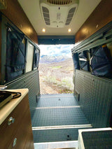 Experience the ultimate RV rental adventure! Cozy van interior with a stunning mountain view from the back.